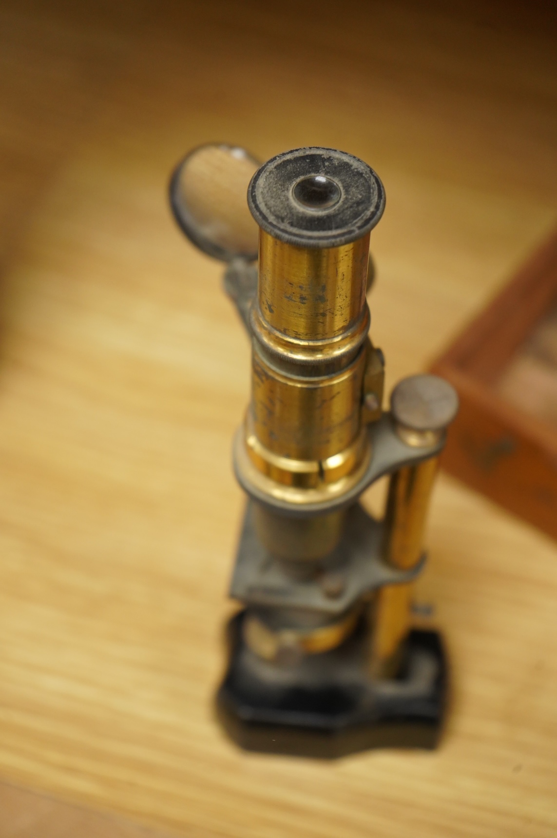 A late 19th/early 20th century French brass compound monocular microscope, height 20.5cms, together with a teak case; 23cm wide, 9cm deep, 7cm high